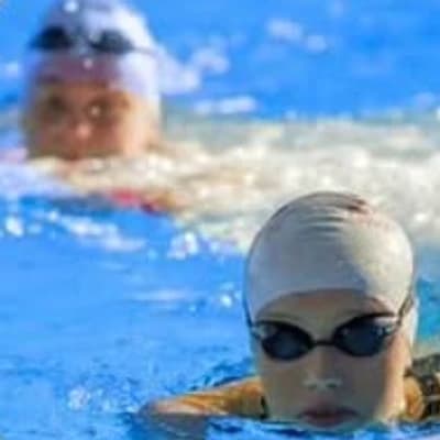 An adult swimmer mid-stroke during a lesson